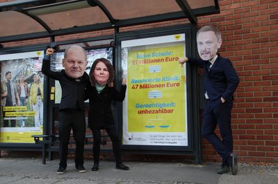 Scholz, Baerbock und Lindner stehen vor einer geadbusteten Anzeigetafel, die für die Vermögensabgabe wirbt. Lindner ist unglücklich.