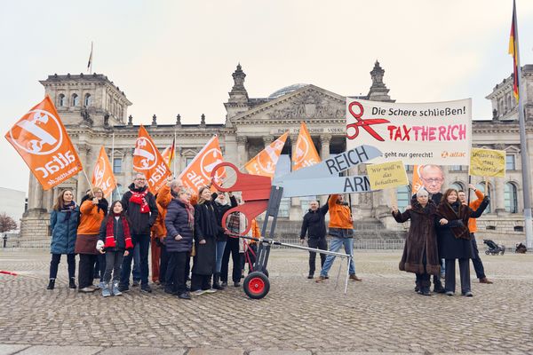 Gruppenbild mit Schere, Banner, Attacies und Bundestagsabgeordneten, die zur Aktion gekommen sind