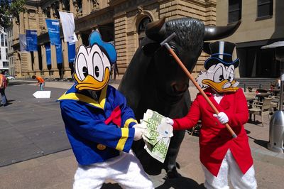 Donald und Dagobert ziehen um das Geld, vor dem Bullen vor der Frankfurter Börse, Dagobert versucht mit seinem Gehstock auf Donald einzuschlagen.