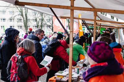 Blick vom Attac-Infostand auf die vorbeilaufenden Demonstrant*innen