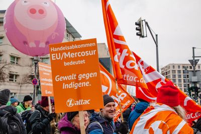 Blick in den Attac-Block mit einem Schild auf dem steht "EU/Mercosur bedeutet Gewalt gegen Indigene"