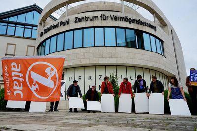 Die Aktivist*innen halten die weißen Rückseiten der Buchstaben vor sich