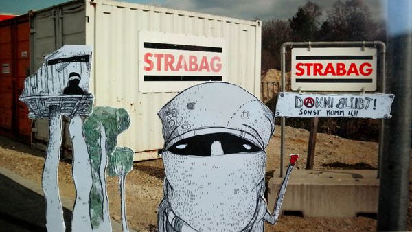 Vor dem Strabag-Container sind bemahlte Scherenschnitte von Bäumen und Menschen, sowie ein kleines Hammer mit der Aufschrift "Danni bleibt sonst komm ich" zu sehen