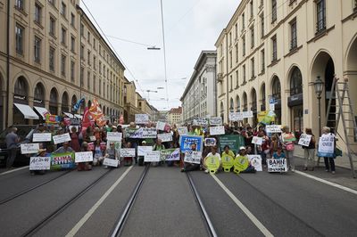 Gruppenbild mit Schildern und Organisationsfahnen auf der Straße