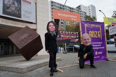 Baerbock und Scholz stellen sich zufrieden vor die Vermögenssteuertür, links ist der Eingang ins Willy-Brandt-Haus und ein Großer Würfel mit dem SPD-Logo erkennbar