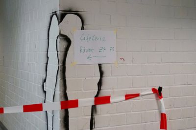 Bild von einer Wandecke in der Schule, bei der zwei Silhouetten an den Wandseiten so aussehen, als wenn sie sich küssen. Daneben ist ein Schild mit der Aufschrift "Cafeteria, Räume Z2–Z7 nach links"